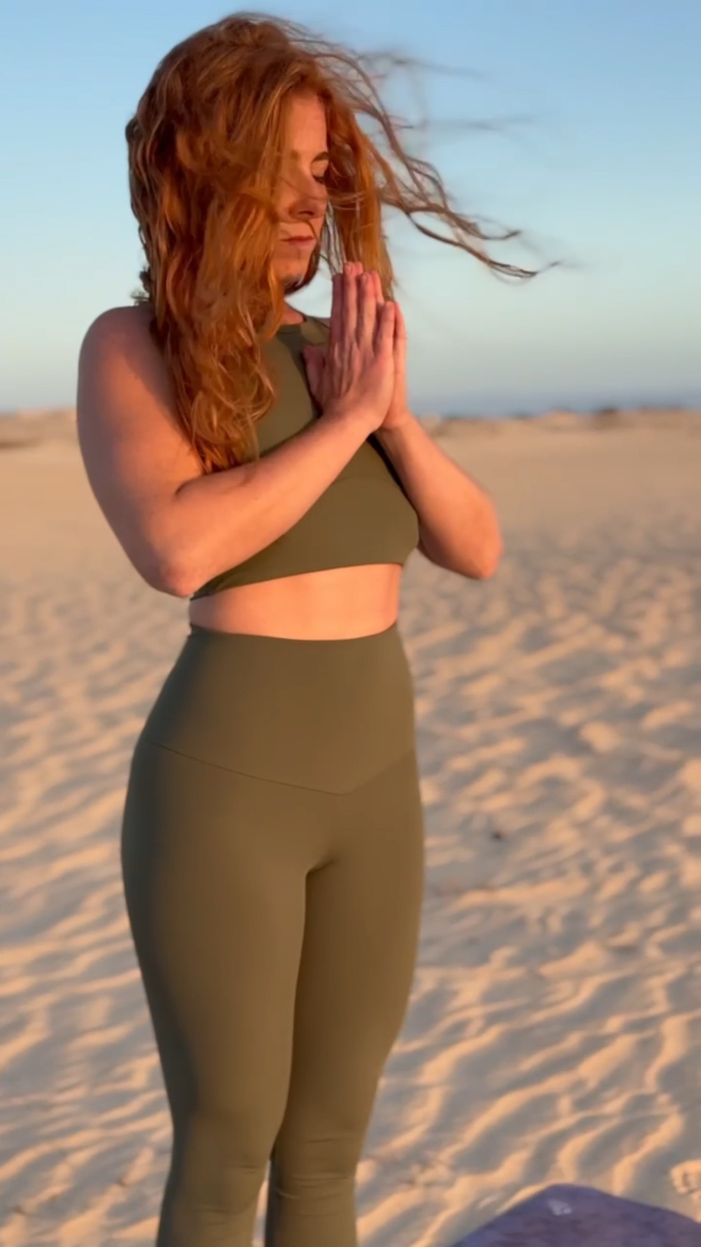 Laura con le mani al cuore durante una pratica nel deserto