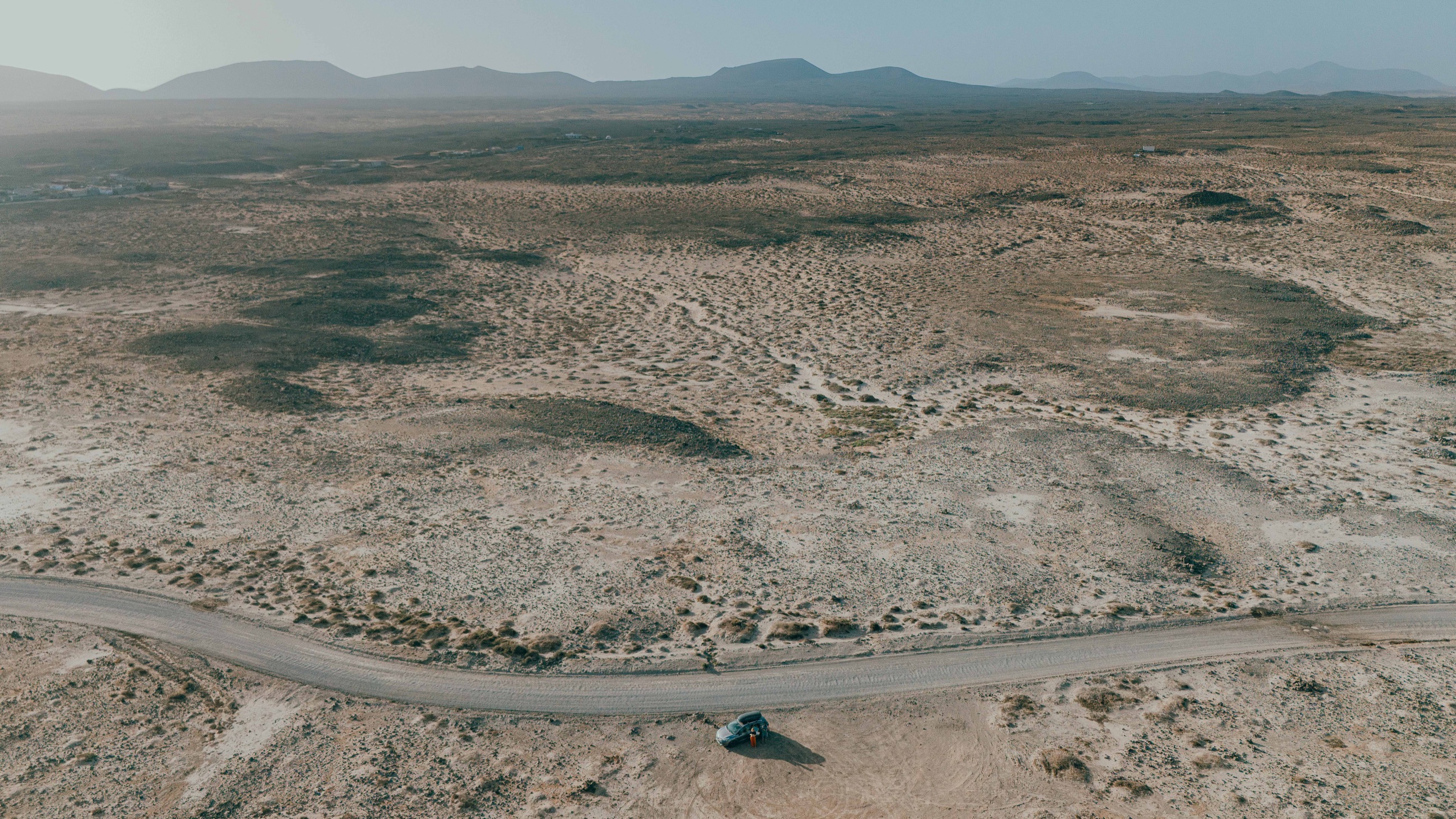 Un’auto su una strada nel paesaggio vulcanico di Fuerteventura